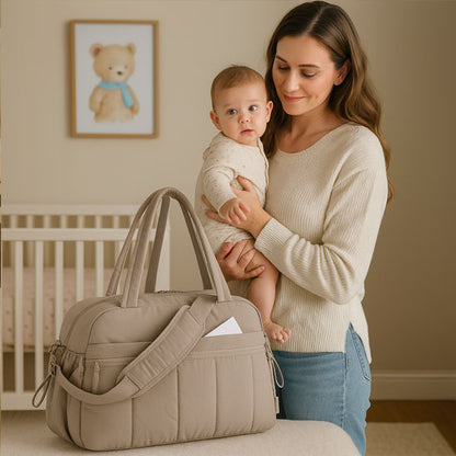 maman avec son bebe et le sac a langer gris